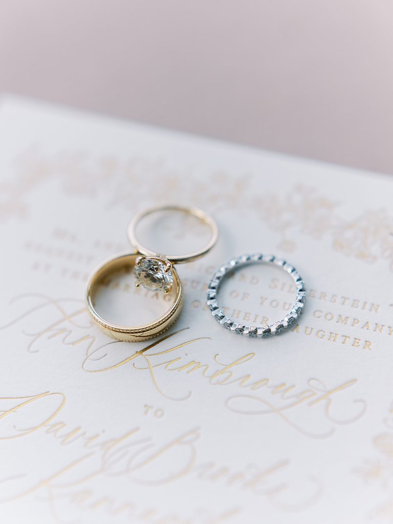 Three wedding bands on a neutral background.