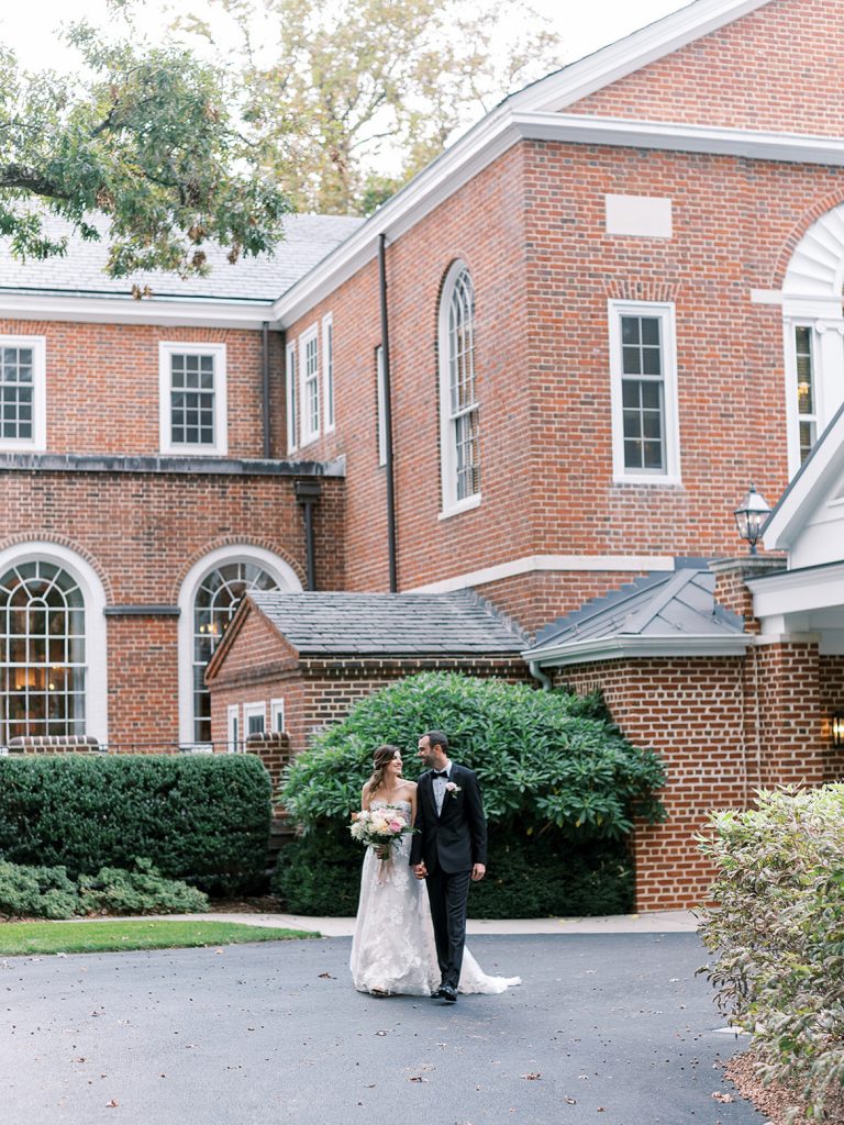 Bride and groom posing in front of Baltimore Country Club wedding venue.