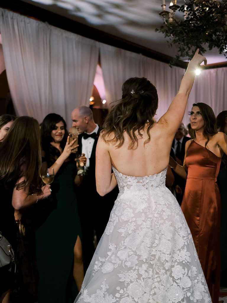 Bride dancing with her hand in the air.