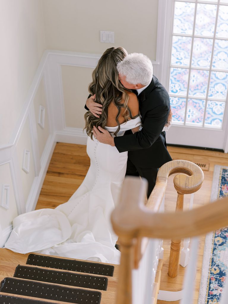 Bride hugging her father at the bottom of a staircase, photographed by New York Wedding Photographer Sophie Kaye.