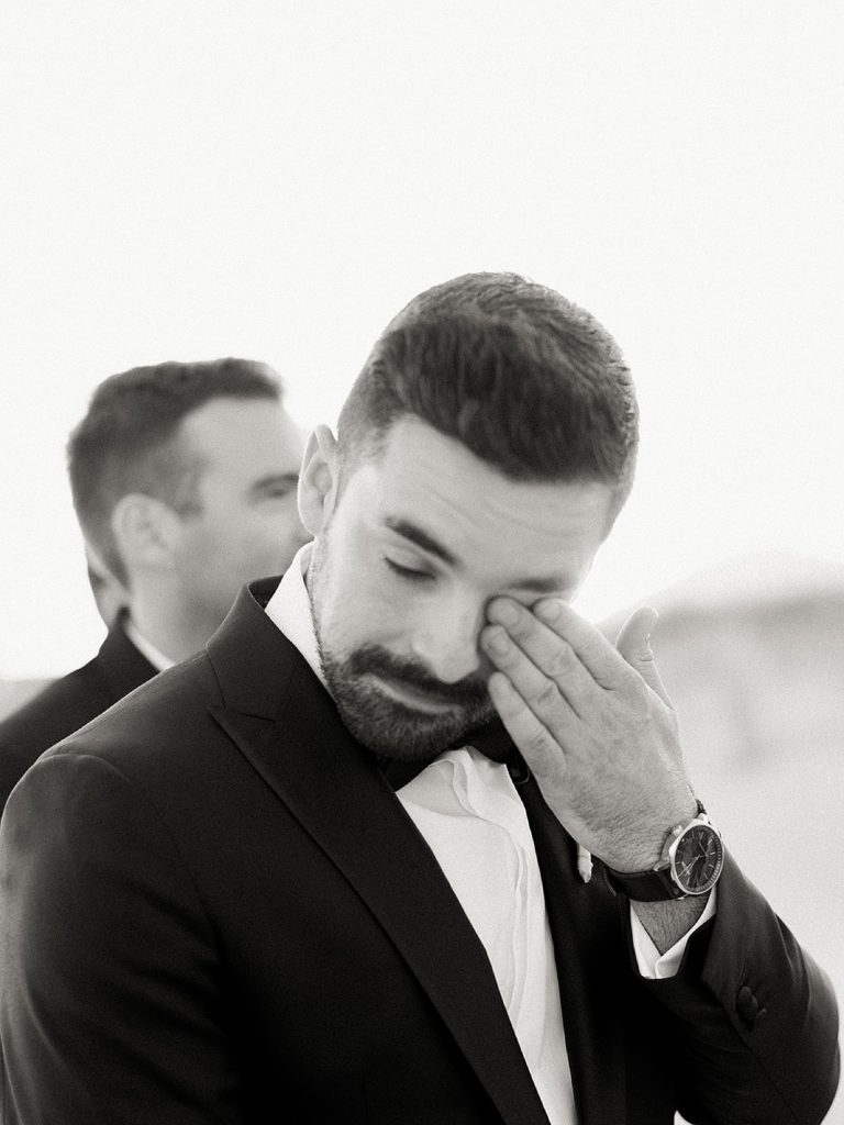 Groom wiping away a tear as bride walks down the aisle. Shot by NYC wedding photographer, Sophie Kaye.