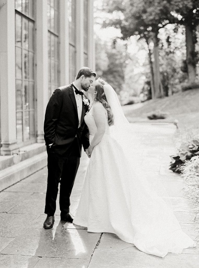 Bride and groom sharing a kiss before their garden wedding at Winterthur Museum.