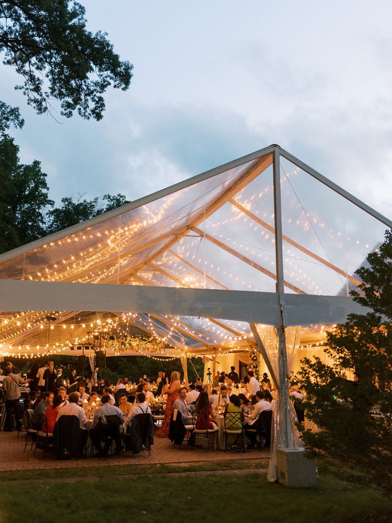 Reception under a clear tent with twinkle lights outdoors in Delaware. 