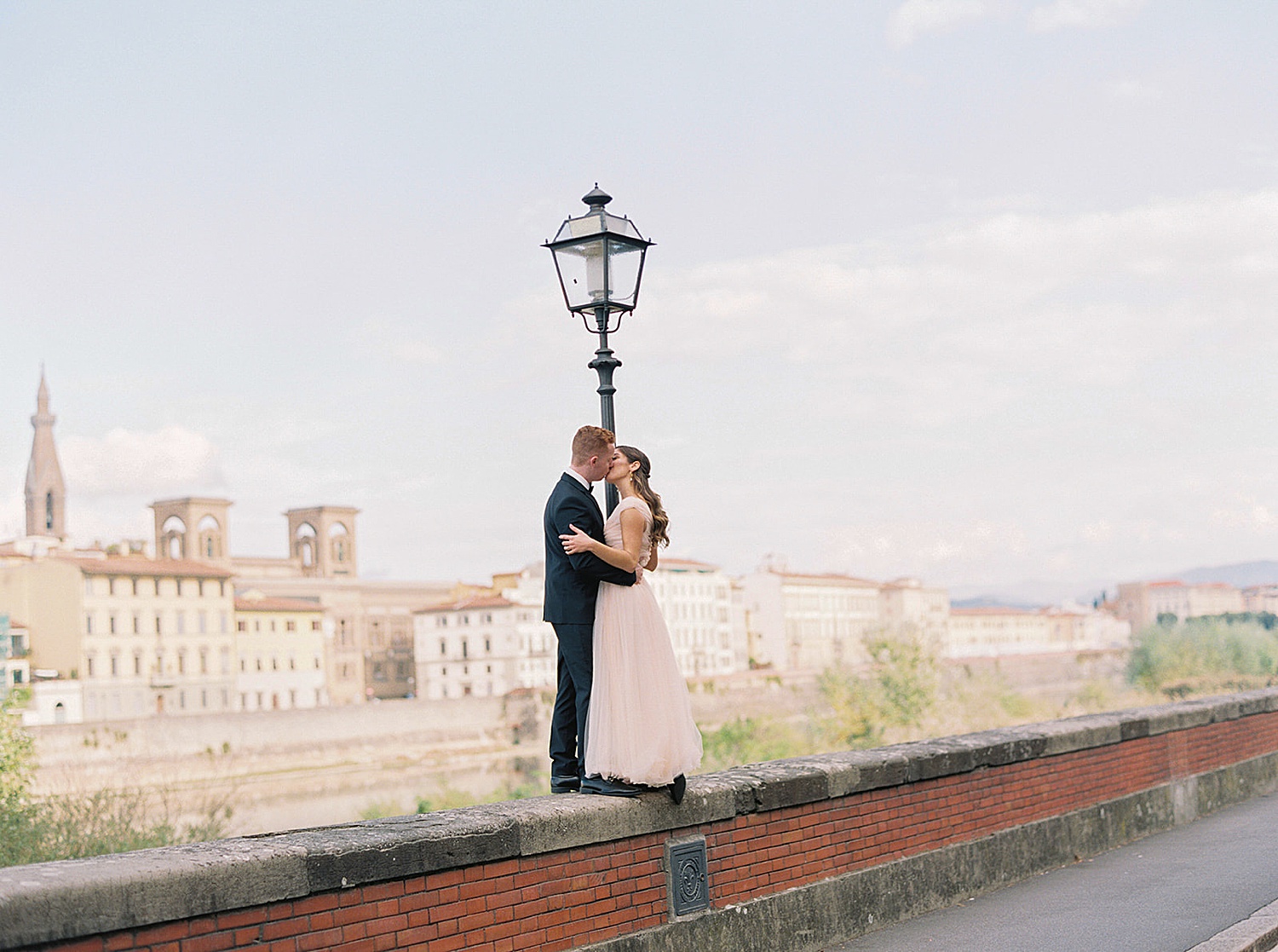 couple kissing on bridge in Florence Italy with luxury wedding photographer