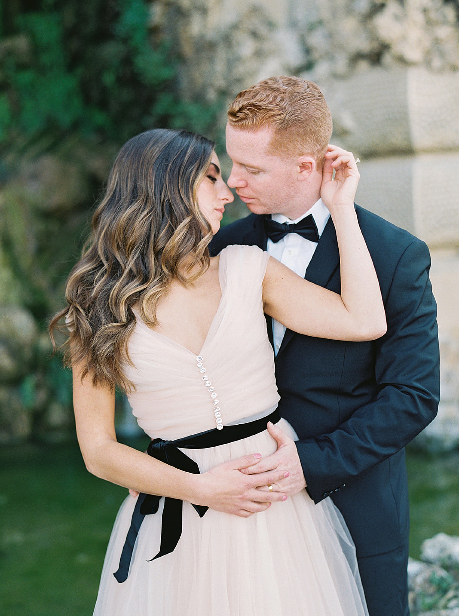 couple shares intimate kiss on Florence honeymoon while wearing luxury wedding dress with destination wedding photographer