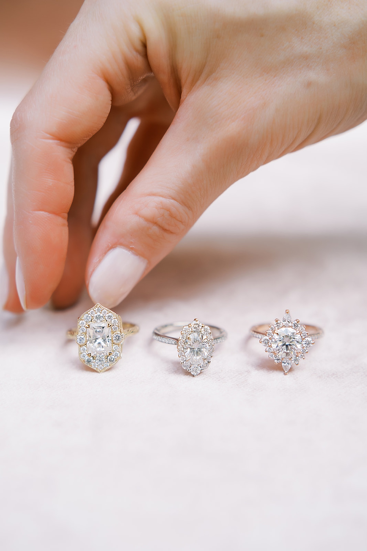 picking between three diamond rings laying on flay lay with New York luxury photographer 