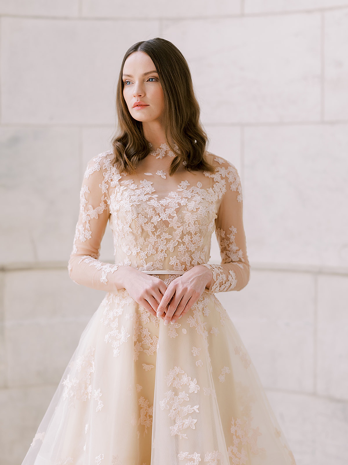 woman in cream lace wedding dress with long net sleeves poses for NYC Fashion Photographer