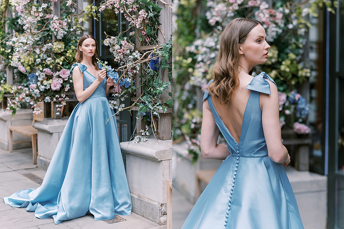 bride in nontraditional blue wedding gown poses with floral background for NYC Fashion Photographer
