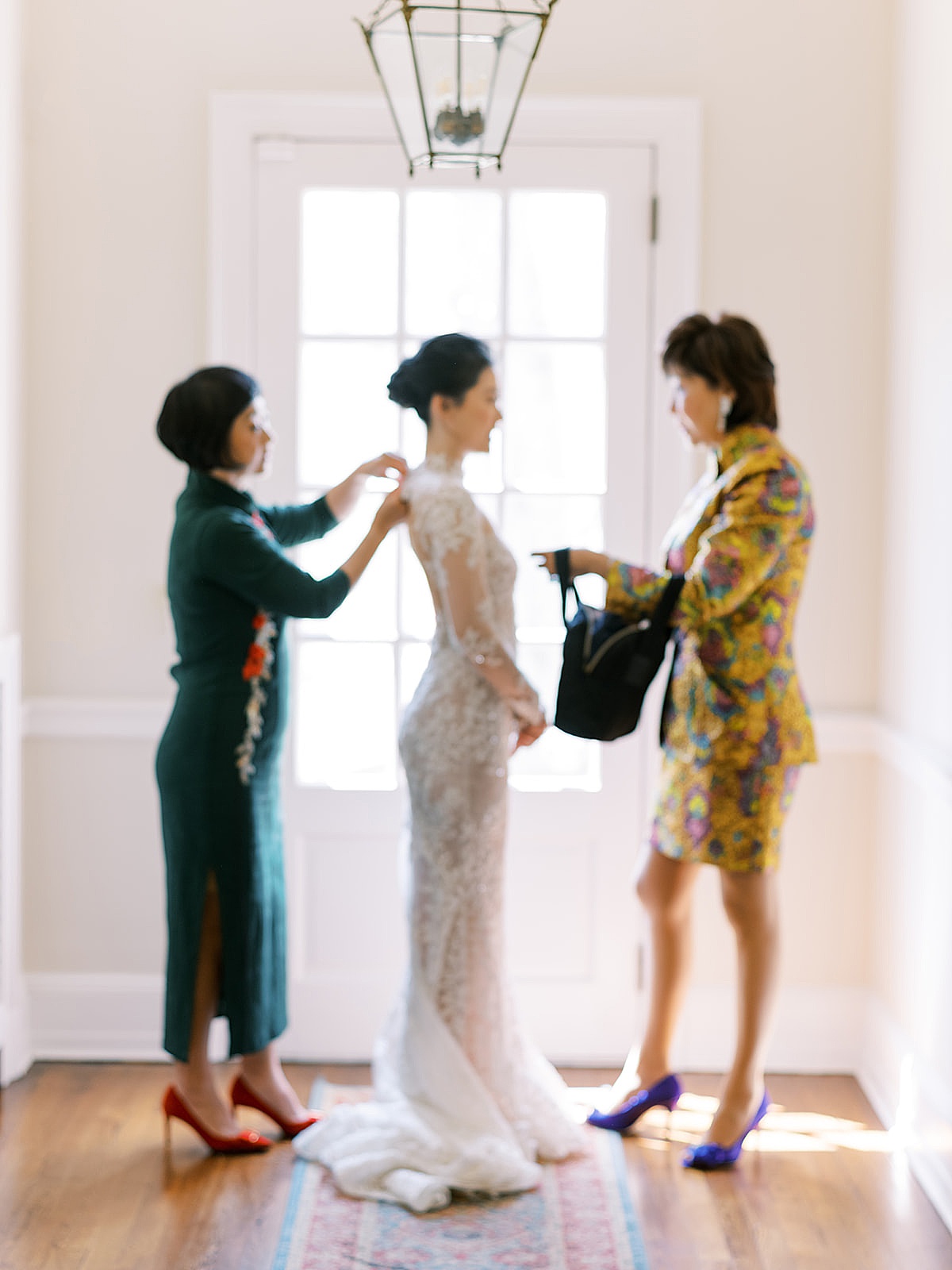 Bridal party and mother of the bride help woman into her couture gown during Westchester Blue Hill Wedding