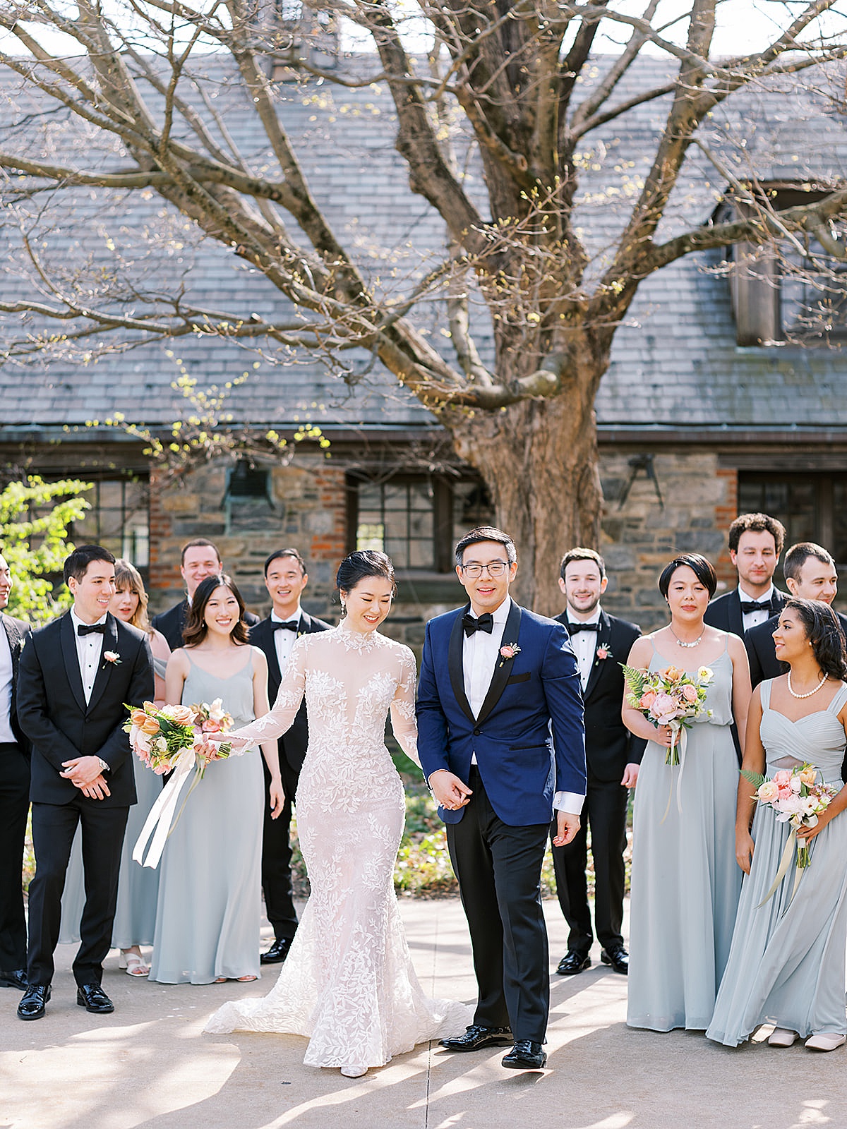 Black tie wedding party pose outdoor with pastel bouquets before elegant ceremony shot by Destination Luxury Photographer