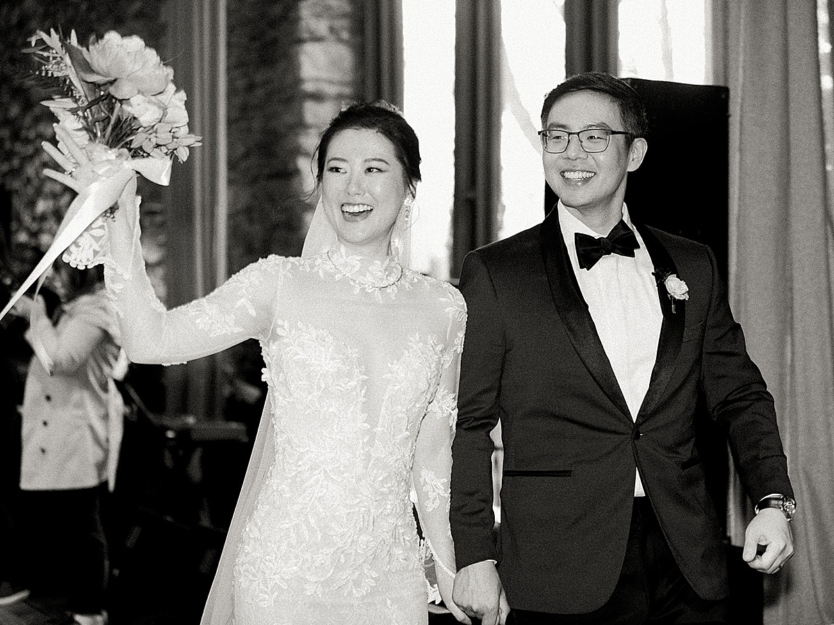 newly wed bride and groom smile and wave after elegant wedding in new york shot by Sophie Kaye Photography